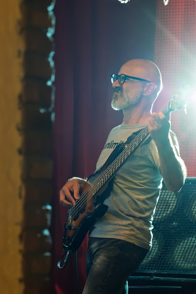 Bass player backlit in a haze of stage light